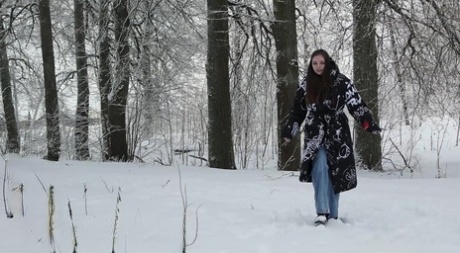 A rapariga bonita Vika é apanhada com as calças de ganga para baixo enquanto mija na neve