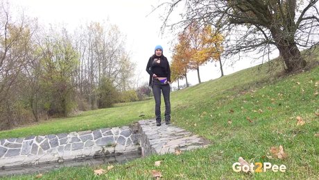 Garota morena Freya Dee toma um xixi em um muro de contenção em um dia frio