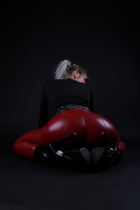 Platinum blonde Avengelique models in glasses while wearing latex pants