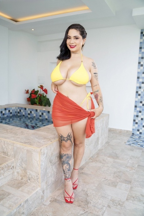 Thick Latina chick Kim Velez releases her knockers from a bikini to get naked