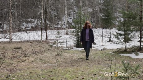 Natural redhead Nikky B takes a badly needed pee while out in the woods