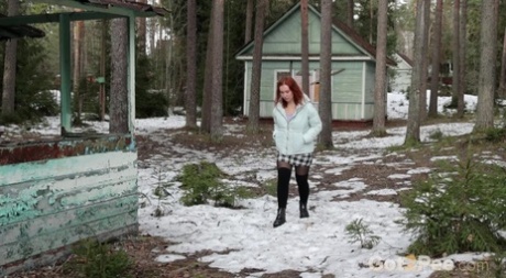 Redheaded girl Nikky B takes a piss on a chilly day upon outdoor stairs