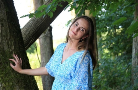 Girl next door type Anna Love gets completely naked amid mature trees