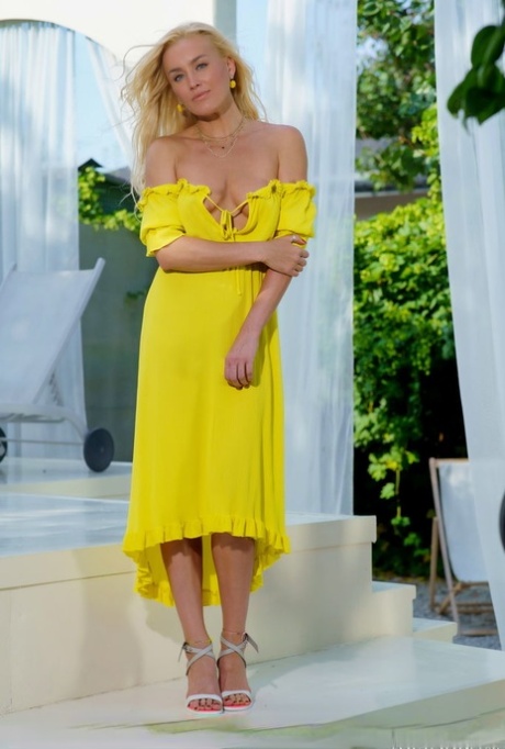 Hot blonde teen Liza B slips out of a yellow dress to pose in the nude