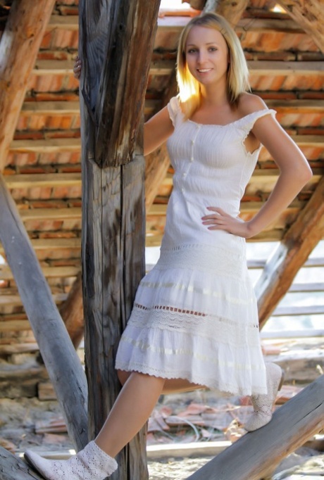 Blonde teen Ilona D strips to her boots at a rustic location