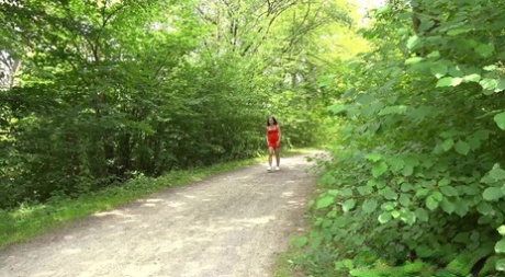 Brunette chick Ali Star takes a piss on a bench alongside a rural walking path