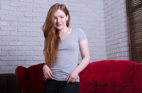 Teen solo girl with natural red hair Anika B gets totally naked on a sofa