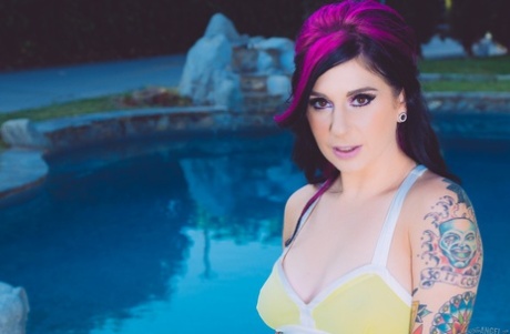 Tattoo-Model Joanna Angel steht nackt vor dem Pool, nachdem sie ihr Kleid ausgezogen hat