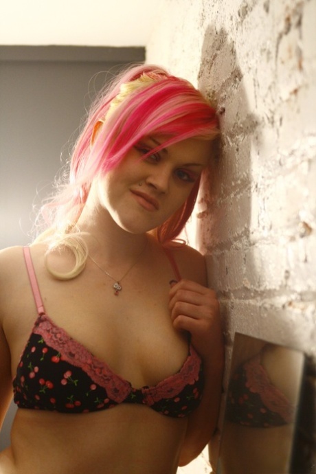 Den tatoverte jenta Jade Jolie har farget hår mens hun poserer naken i en fjærboa.