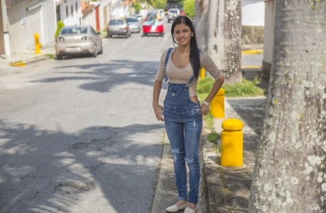 Одетая брюнетка-подросток Денисса Гомес демонстрирует свое красивое лицо в джинсовом комбинезоне