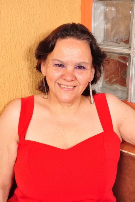 Übergewichtige lateinamerikanische Hausfrau zieht rotes Kleid aus und posiert in Dessous und Strumpfhosen