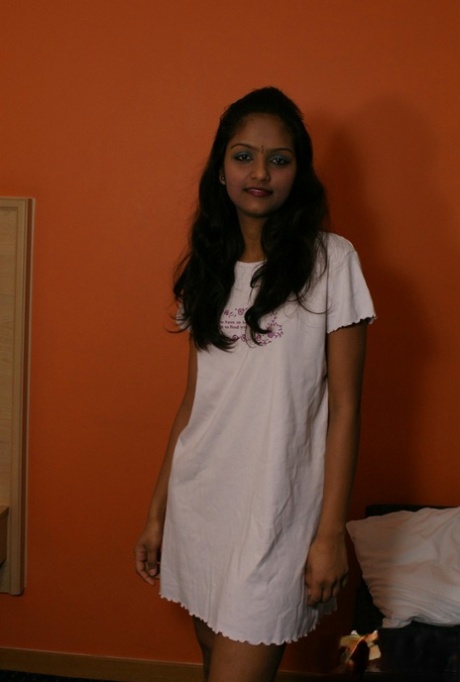 Indyjska kobieta Divya podnosi białą sukienkę, aby odsłonić pochwę