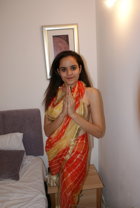 Indiaas solomeisje bevrijdt haar natuurlijke tieten uit haar kleding op een bed