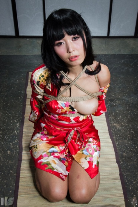 La bella ragazza asiatica Marica Hase è sospesa con corde e unghie dei piedi rosse