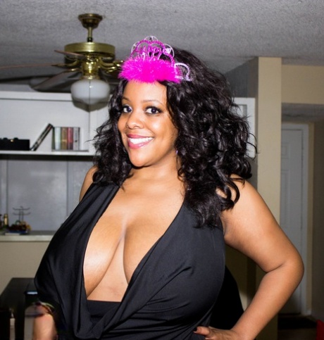 Big black girl Kristi Maxx sets her big boobs free of a black dress in heels