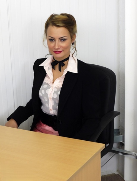 不動産業者のケリー・スミスは、オフィスの机の上でサテンのランジェリーを身に着けている。