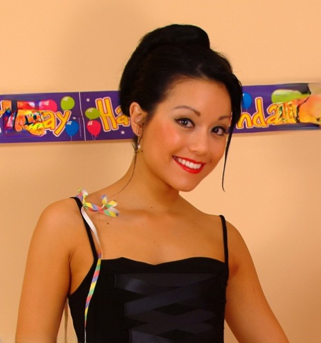 Den asiatiske pinup-model Petra Lily So holder balloner, mens hun blotter sine små bryster.