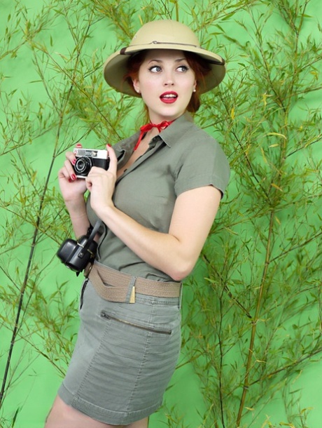 Pelirroja modelo pinup vintage en lencería roja hace alarde de sus grandes tetas naturales