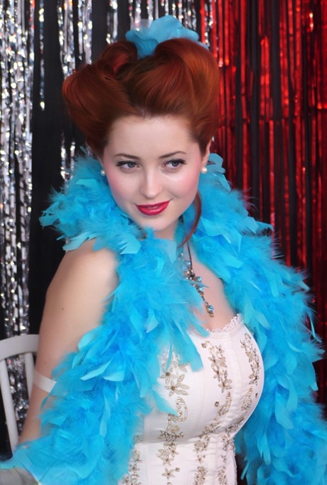 Den nydelige pinup-modellen Lucy V stripper i burlesk stil på en glitrende scene.