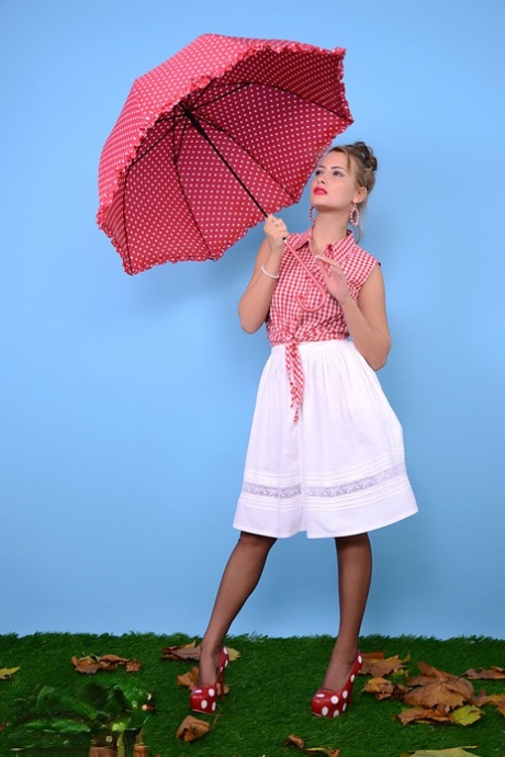 Pinupmodellen Kelli Smith tappar kläder och slang när hon håller i ett paraply