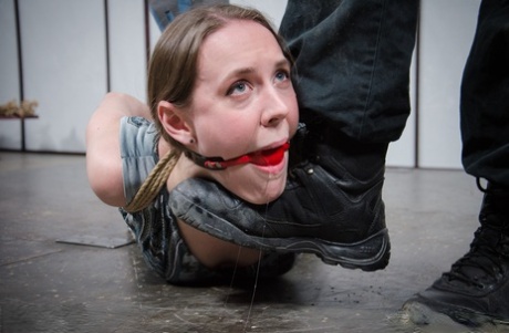 Den lyshudede pige Sierra Cirque hænger i et reb, mens hun bliver tortureret.