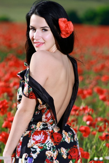 Ciemnowłosa nastolatka Lola Marron rozpina sukienkę i pozuje nago w polu kwiatów