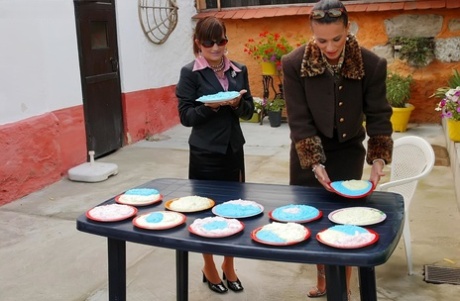 Lesbianas completamente vestidas se cubren mutuamente con relleno de tarta de arándanos