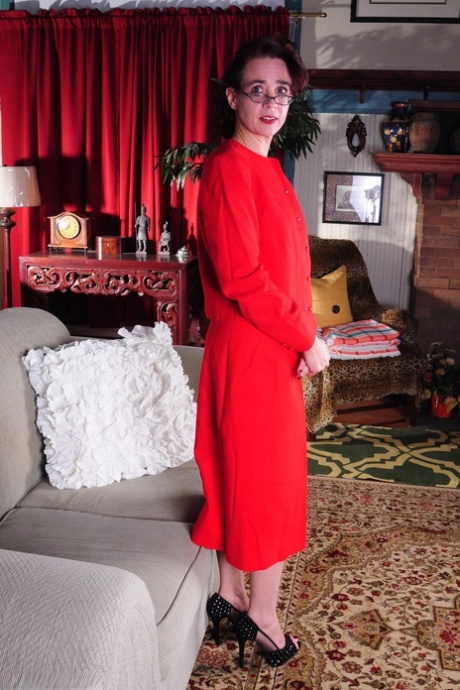 Dojrzała amerykańska gospodyni domowa zdejmuje czerwoną sukienkę, aby modelować w bieliźnie