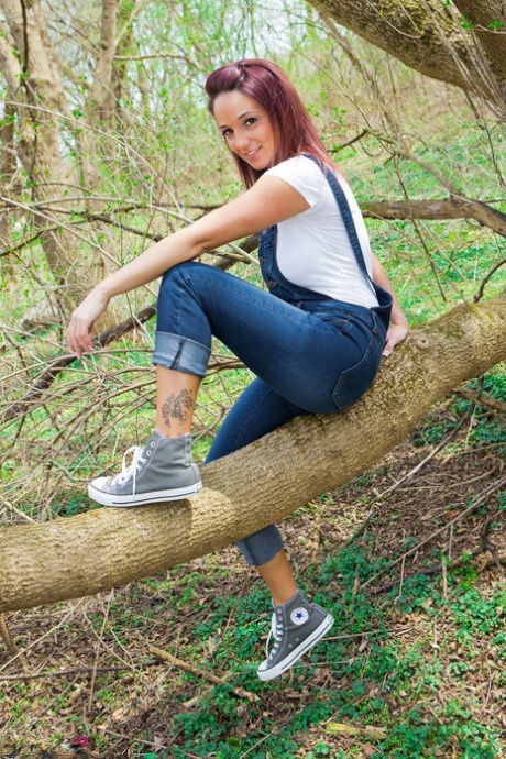 Nikki, une superbe rousse, enlève sa chemise moulante dans les bois.