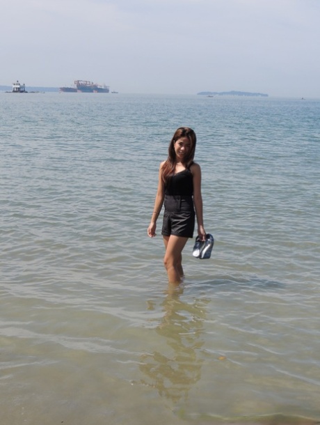 Asian girl Chelsy wades in the sea before making her nude debut on a bed