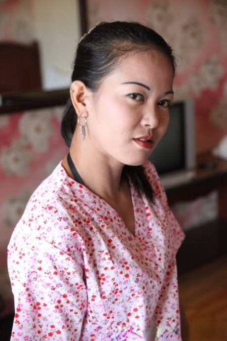 Азиатская любительница Митч обнажает свою подстриженную муфту, сидя на кровати