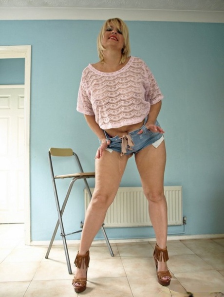 Rubia mayor Daniella English deslizando sus pantalones cortos sobre su gran culo