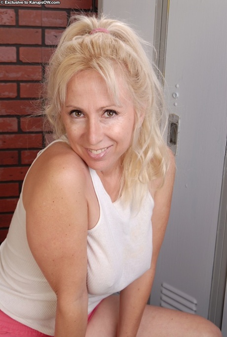 Blonde mature se déshabillant et exposant sa chatte rose en gros plan