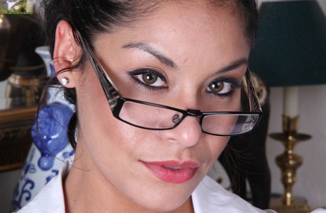 Latina sorridente e tentadora de óculos a despir-se e a mostrar a sua cona suculenta