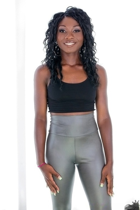 Ebony sugar in zilveren legging die zich uitkleedt en haar kont blootstelt