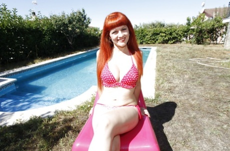 Roodharige Latina speelt met haar tieten en doet haar bikini uit bij het zwembad