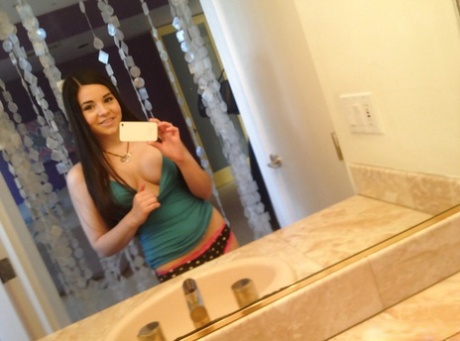 Lief latina schatje kleedt zich uit en maakt selfies in de badkamer