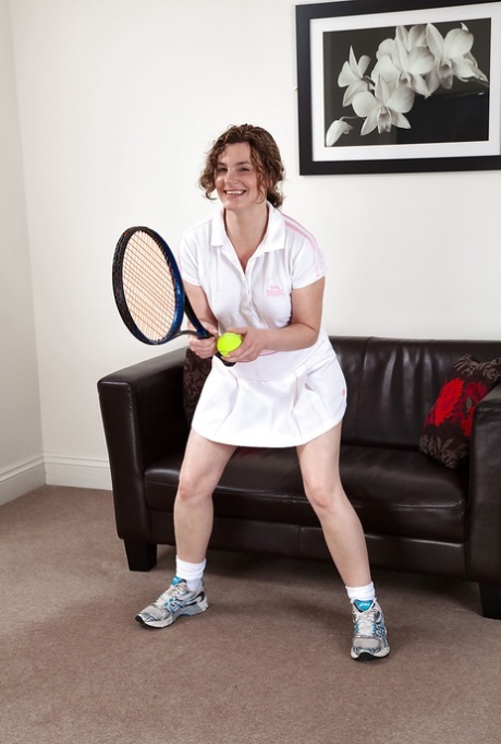 Speelse rijpe tennisspeelster doet haar slipje uit en laat haar borstelige kut zien