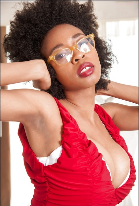 Ebony-luder demonstrerer sine store pupper i sexy briller og røde truser