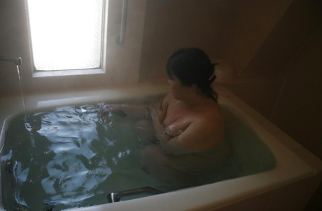 Den mogna brunetten Eiko Imamiya njuter av ett varmt bad och visar sina asiatiska bröst