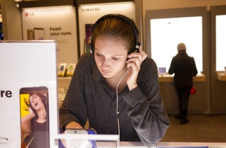 Magere speelse blonde tiener Reese Berkman buigt voorover in een winkel