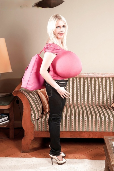 Moden blondine i trange jeans Beshine som viser sine ekstremt store juggs