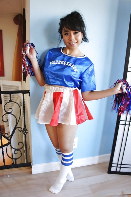 Petite Oriental cheerleader May Lee visar svarta trosor under kjolen