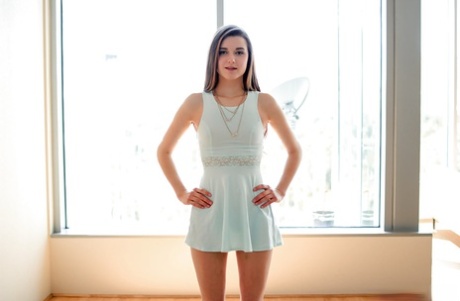 Junges Mädchen Alex Mae posiert im kurzen weißen Kleid vor dem Strippen für Anal