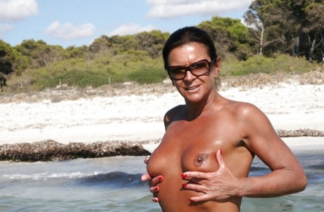 Desnuda británica Lady Sarah mostrando coño maduro perforado al aire libre en la playa