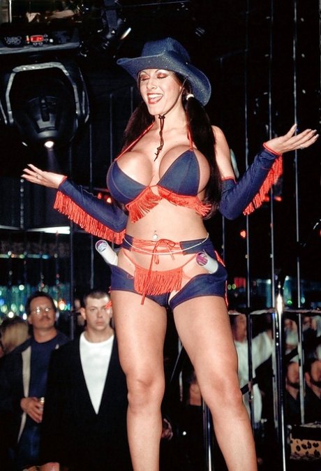 La MILF aux gros seins Crystal Gunns enlève sa tenue de cowgirl dans un club de strip-tease.