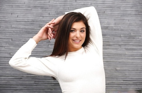 Leah Gotti pose habillée en jeans avant de dévoiler son cul et ses seins.