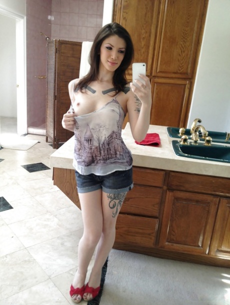 Tattooed brunette babe Indigo August taking selfies of shaved pussy