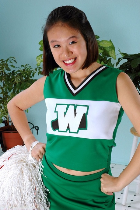 Amateur Asian freeing big tits and ass from beneath cheerleader uniform