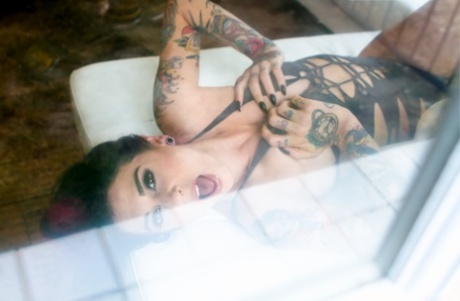 Zwaar getatoeëerd model Joanna Angel doet haar sensuele zwarte onesie uit